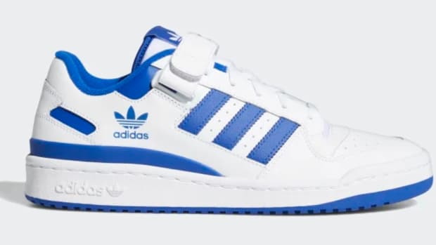 Side view of white and blue adidas shoes.